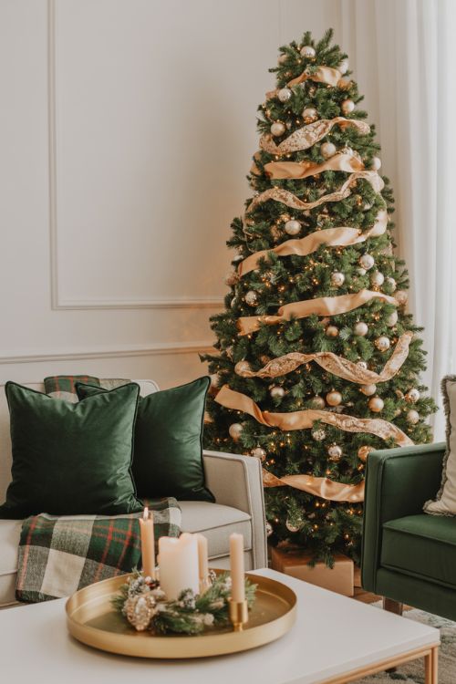 Elegant living room Christmas decor with green and gold color palette, velvet pillows, festive tree, and cozy holiday accents.
